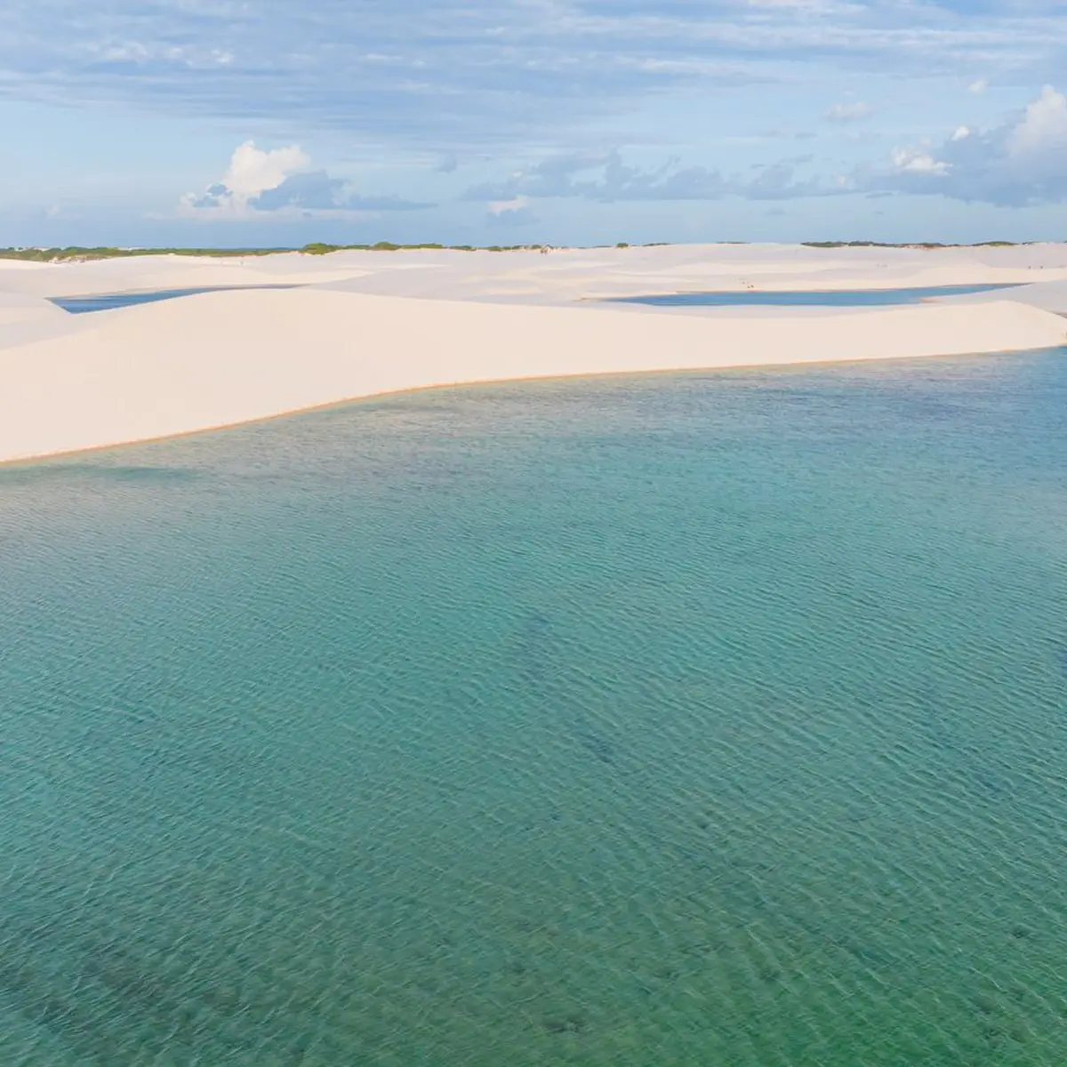 Lagoa de água verde entre as dunas brancas dos Lençóis Maranhenses
